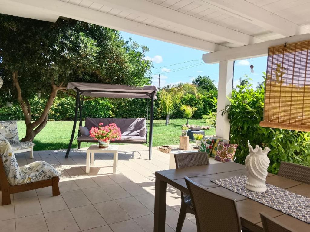 eine Terrasse mit einem Tisch, Stühlen und einem Pavillon in der Unterkunft Casa vacanze tizy in Ragusa