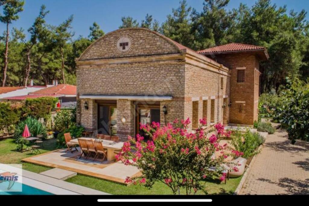 uma pequena casa de tijolos com um pátio e flores em Ultra Lüx Tarihi Villa em Yenice