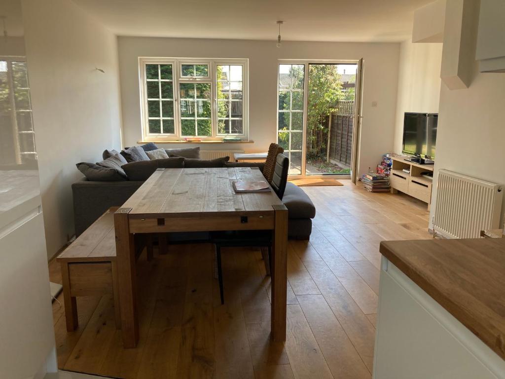 a living room with a table and a couch at Pristine 3 Bed Home For Family or Business Stays, Great Location, FREE Parking, Park Views, Sleeps 5! in Ashford