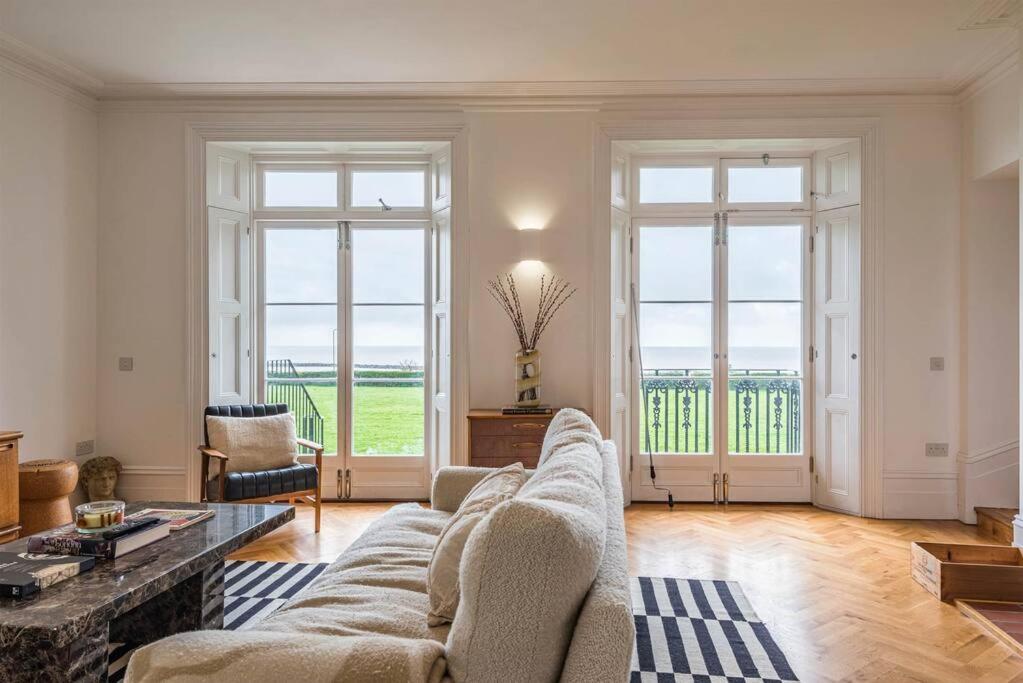 sala de estar con sofá y 2 ventanas grandes en Royal Channel Retreat - Stunning apartment - glorious views, en Kent