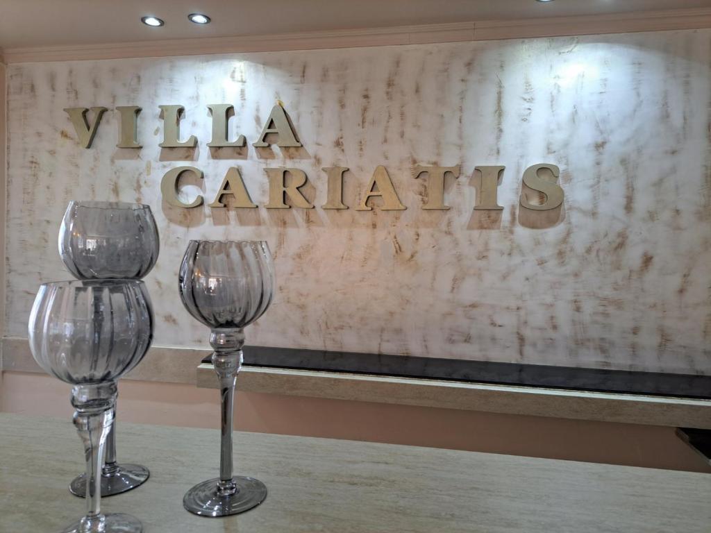 two wine glasses sitting on a table in front of a sign at VILLA CARIATIS in Nea Kalikratia