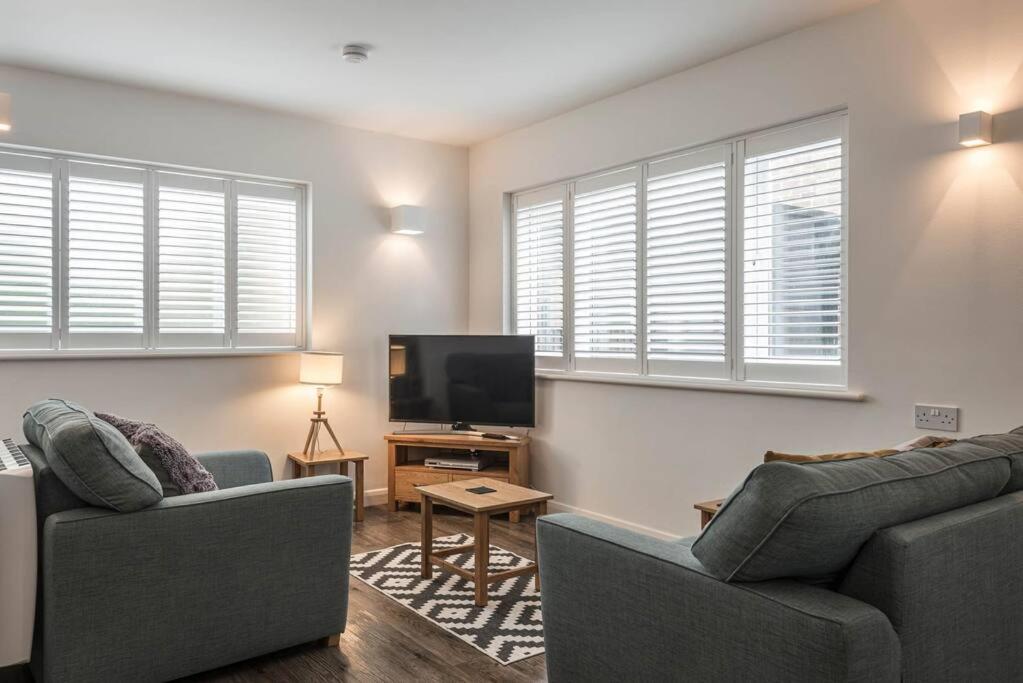 a living room with two couches and a flat screen tv at Seascape - Modern one bedroom, two storey annexe in Kent