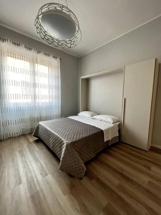 - une chambre avec un lit et une grande fenêtre dans l'établissement Grano - appartamento Lecce centro, à Lecce