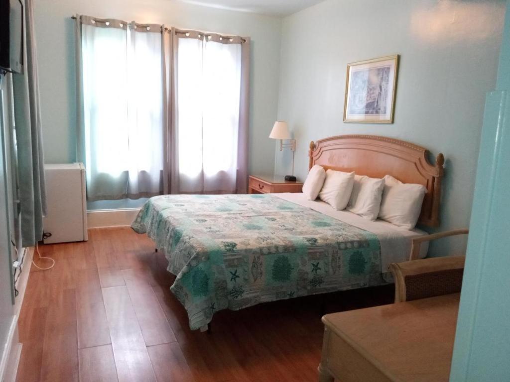 a bedroom with a large bed with a green bedspread at Surf Villa Hotel in Ocean City