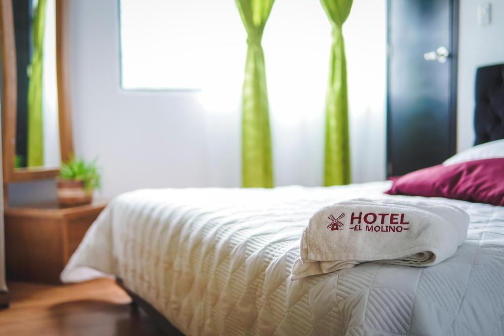 Una cama de hotel con una almohada de hotel. en Hotel El Molino, en Facatativá