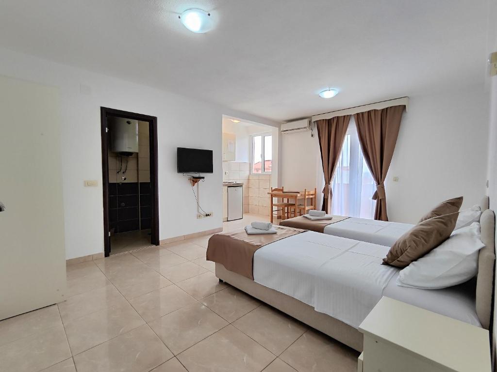 a bedroom with a large bed and a television at Villa Hera in Budva