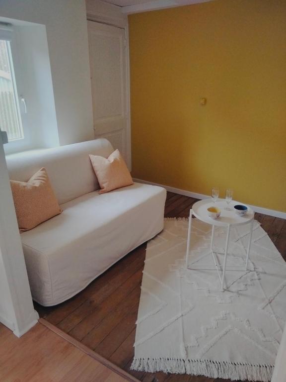 un salon avec un canapé blanc et une table dans l'établissement Le Chalet, à Mers-les-Bains