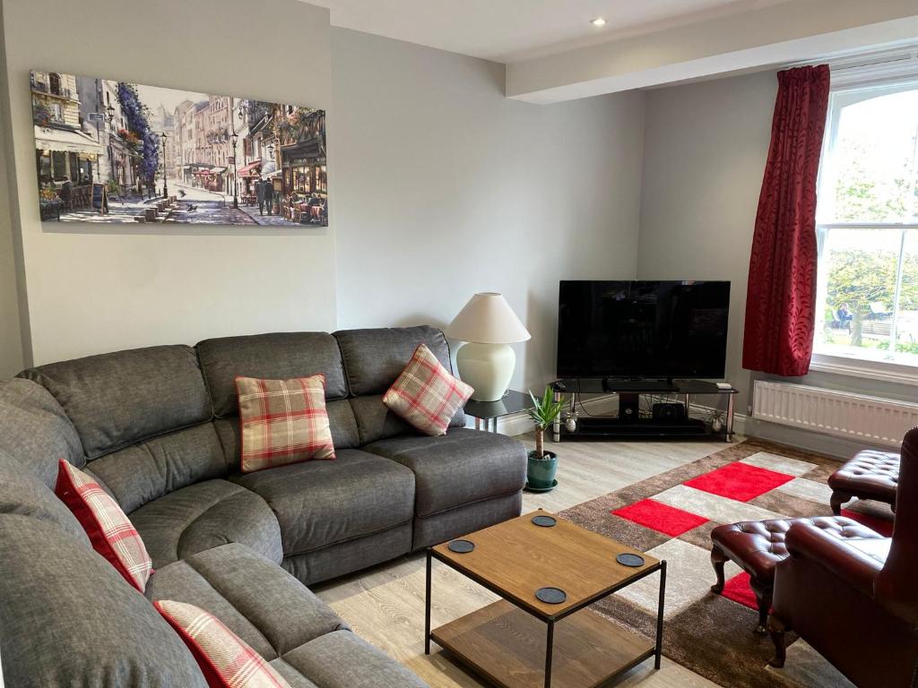 a living room with a couch and a tv at Clarendon Luxury Apartment in Woodhall Spa