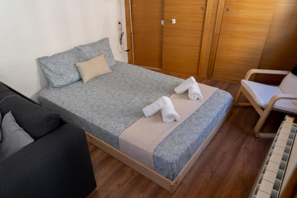 1 dormitorio con 1 cama con toallas en Puerta Real Luxury Apartments Granada, en Granada