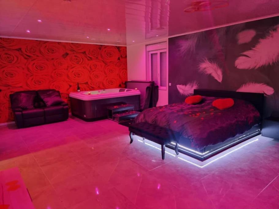 - une chambre rose avec un lit et un billard dans l'établissement Love Room jacuzzi, à Bazoques