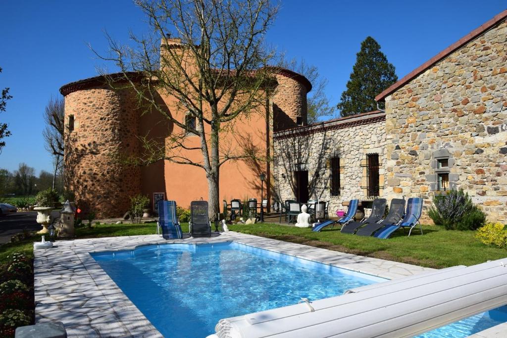 a swimming pool in front of a stone building at Château des Aiguilles in Saint-Rémy-de-Chargnat
