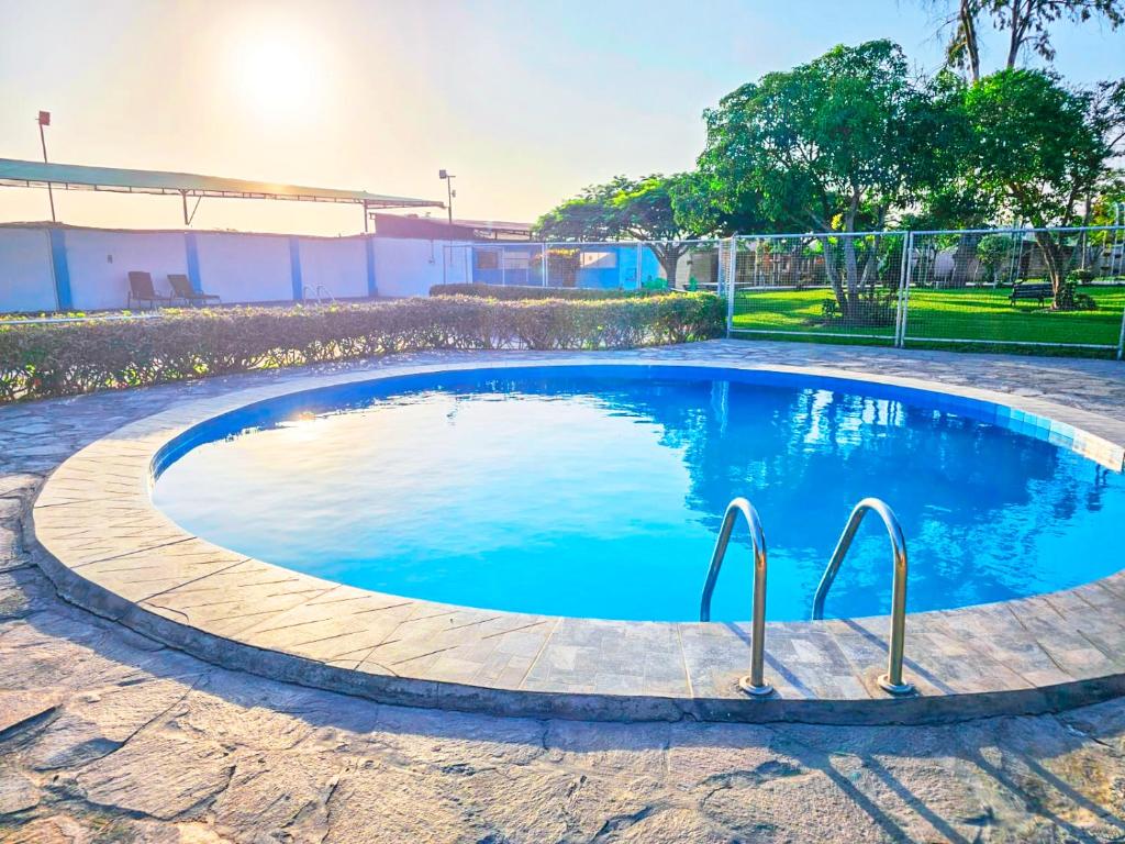 una pequeña piscina con agua azul en un patio en Apart Hotel El Paraíso de Barranca, en Barranca