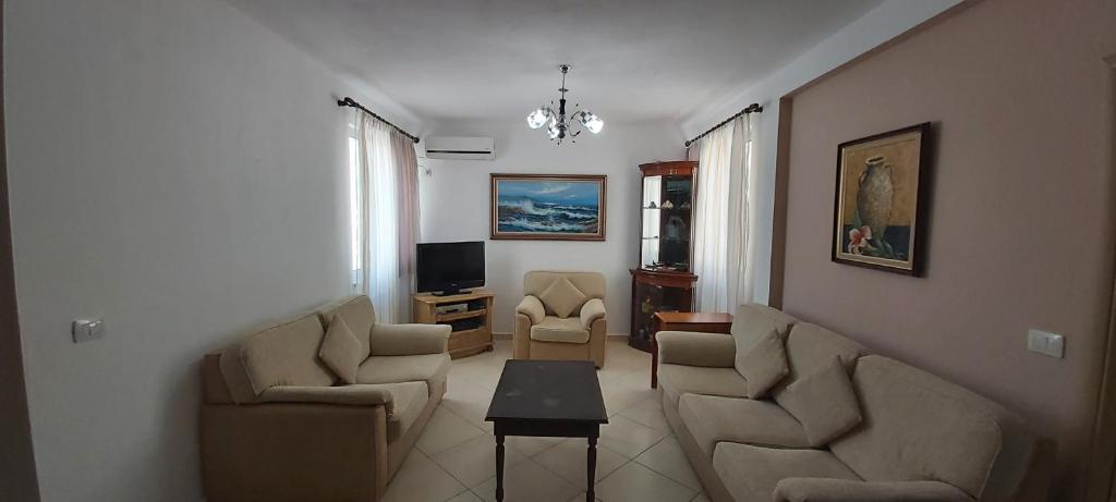 sala de estar con 2 sillas y TV en Family Residence en Shëngjin