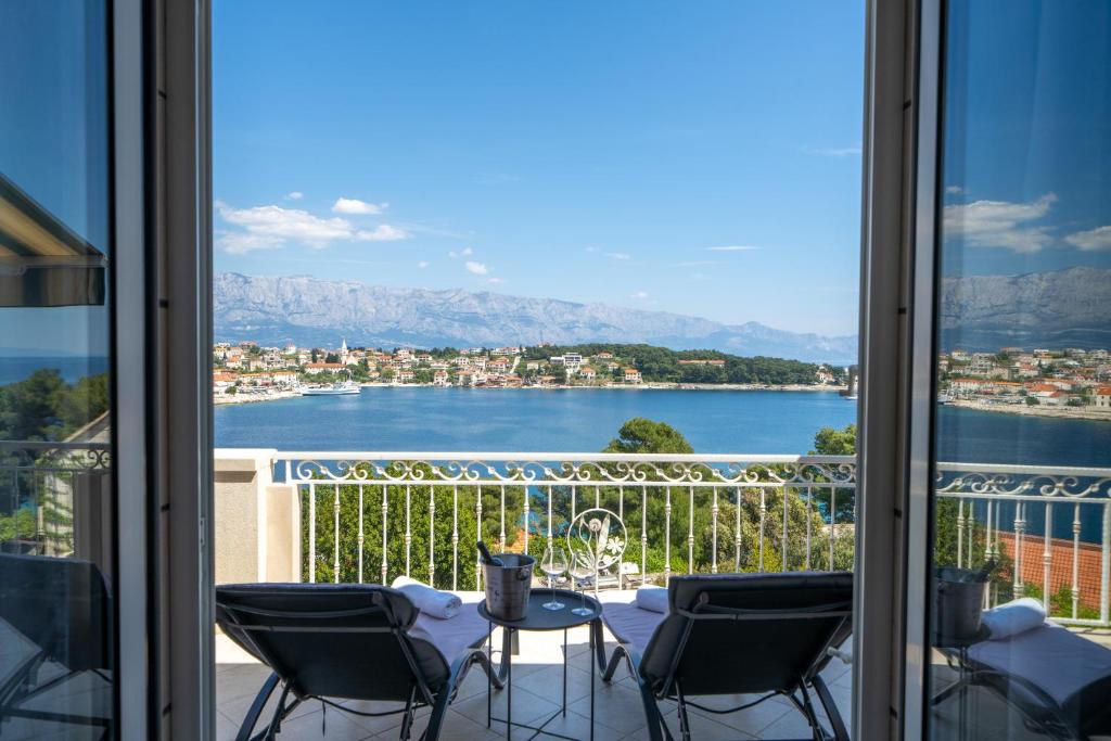 a balcony with chairs and a view of the water at Apartments Siesta in Sumartin