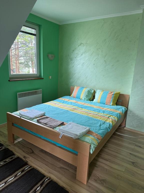 uma cama num quarto com uma parede verde em Diplomat em Divčibare