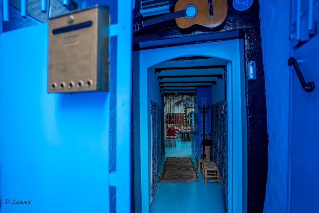une porte bleue avec un panneau sur son côté dans l'établissement Dar Qaysar, à Chefchaouen