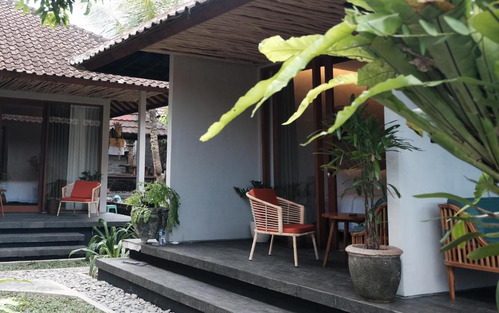 a porch of a house with chairs and plants at Cloudspace Ubud in Ubud