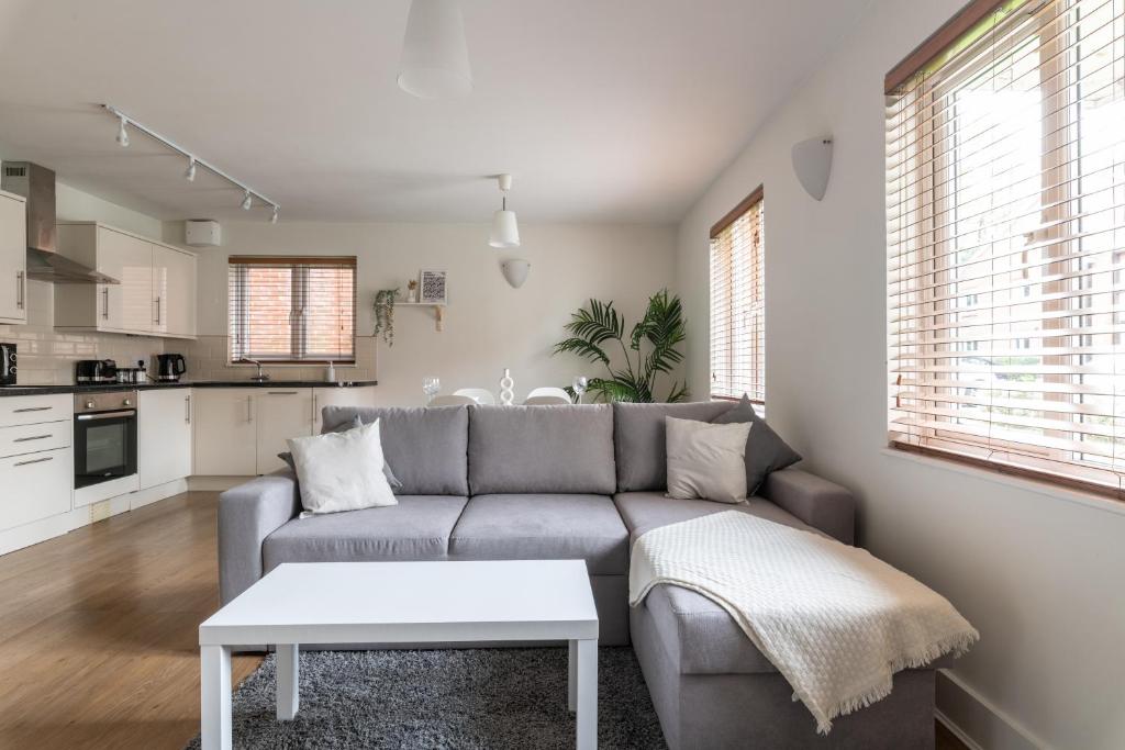 uma sala de estar com um sofá e uma mesa em Bright, Modern, Fully Furnished Apartment - 2 FREE PARKING Spaces - 8 min LGW Airport em Crawley