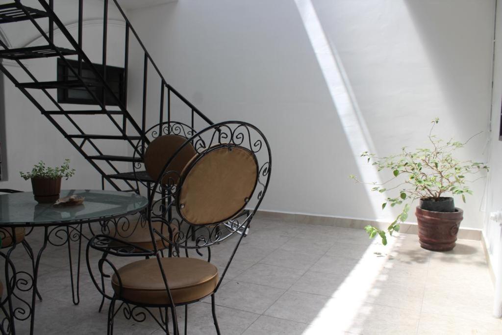 a table and chairs in a room with a spiral staircase at Casa Tenorio Hospedaje in Orizaba