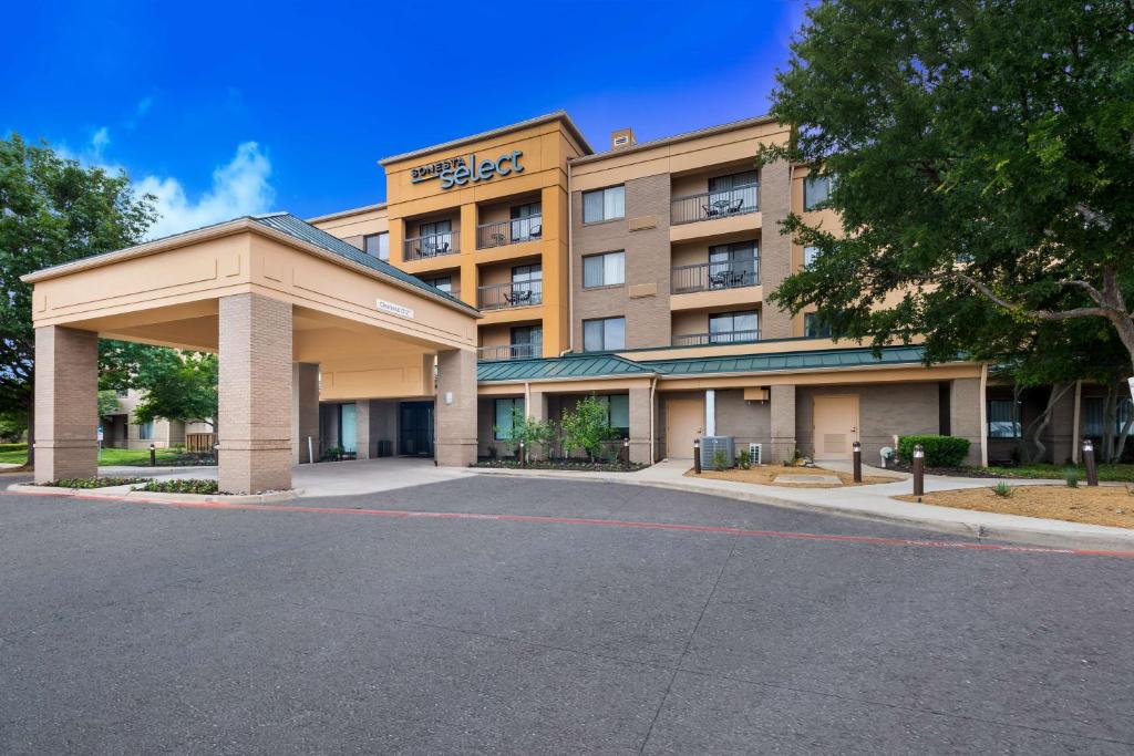 a hotel with a parking lot in front of it at Sonesta Select Dallas Richardson in Richardson