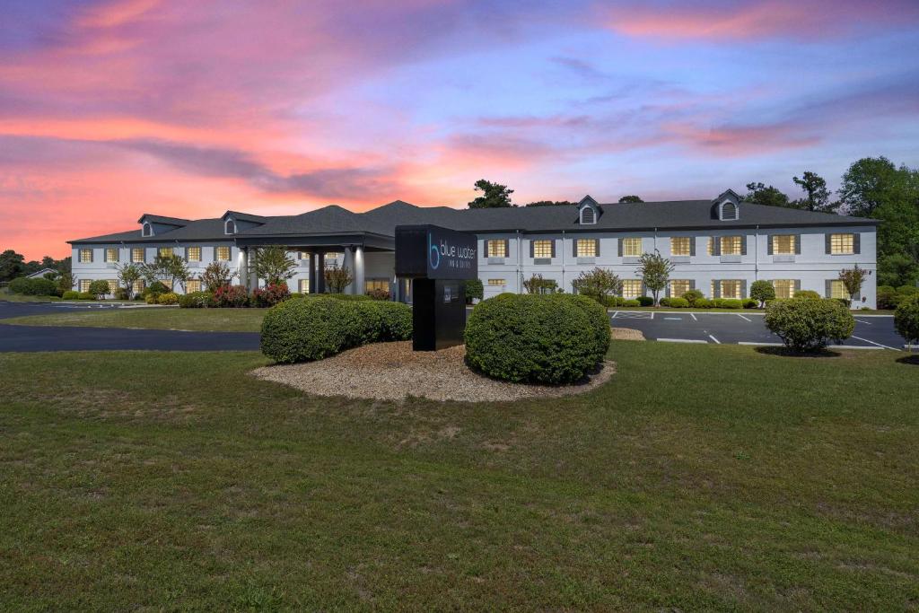 un hotel con un cartel frente a un edificio en Blue Water Inn & Suites BW Signature Collection, en North Topsail Beach