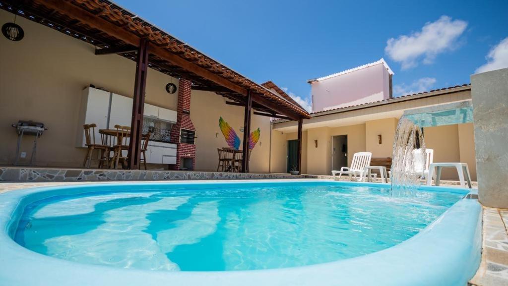 a swimming pool in the backyard of a house at Chalés Sol de Milagres in São Miguel dos Milagres