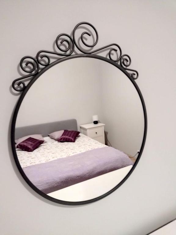 uno specchio appeso a una parete con un letto di ToTuToTam a Varsavia