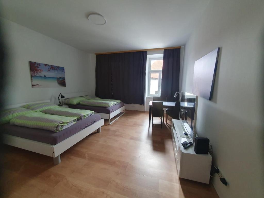 Pokój z 3 łóżkami, biurkiem i biurkiem sidx sidx sidx w obiekcie Apartment Schlössel 24 w Wiedniu