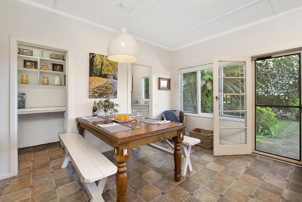 a dining room with a wooden table and chairs at Gowan Ross Cottage in Mount Wilson