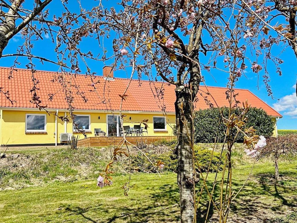 a yellow house with an orange roof at 4 person holiday home in Østervrå-By Traum in Østervrå