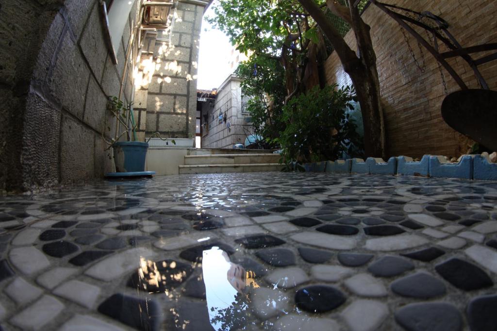 an alley with a tiled floor and a building at alacati antik motel in Çeşme