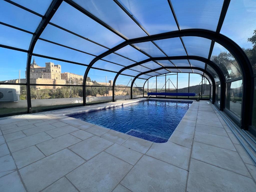 a swimming pool under an archway with a building in the background at Casa Rural Senda de los Lobos in Uclés