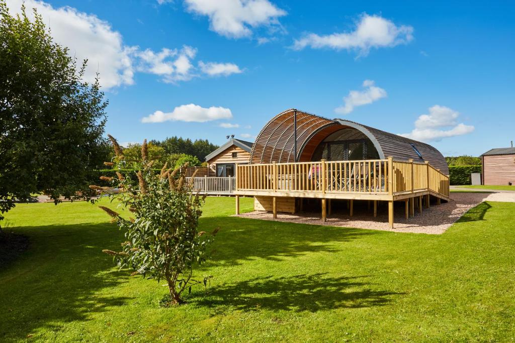 een tuinhuisje met een terras in een tuin bij Braidhaugh Holiday Lodge and Glamping Park in Crieff