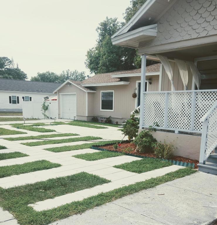 a house with a walkway in front of a yard at sunshine in St. Petersburg
