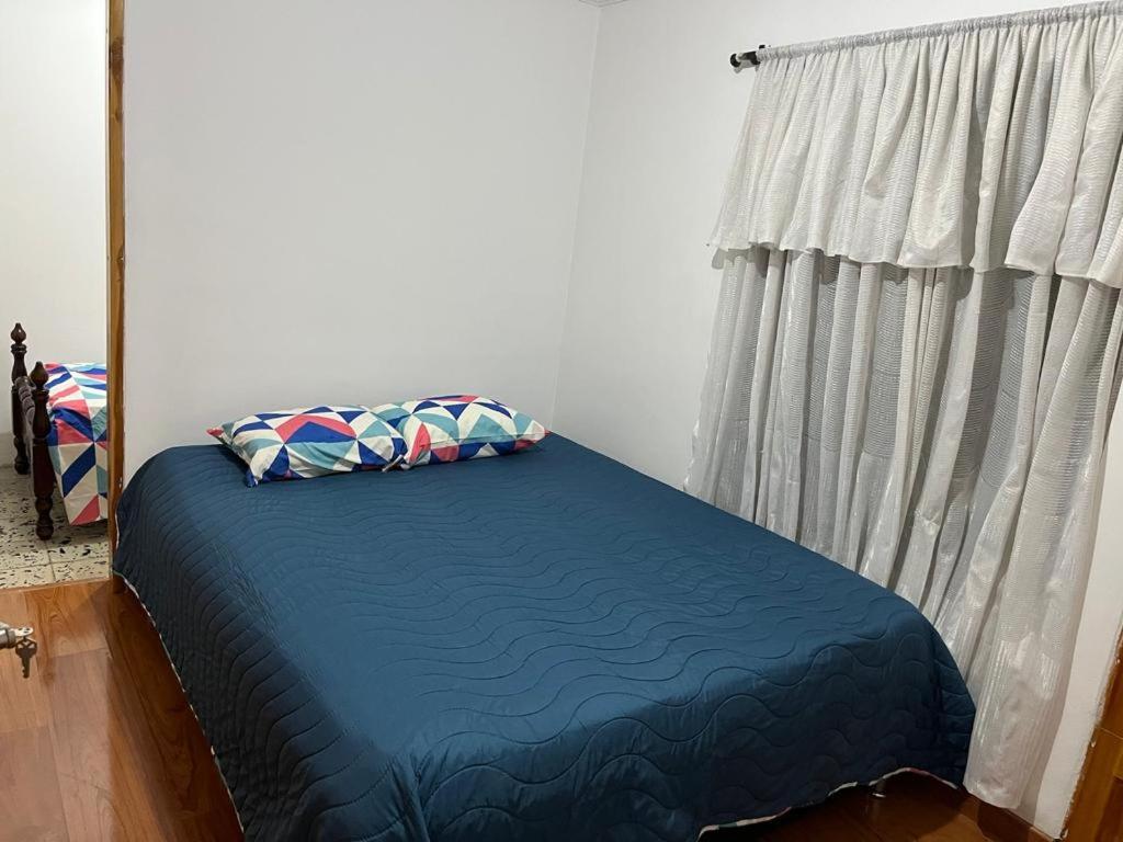 1 cama con 2 almohadas en una habitación con ventana en Pacifica Hostel en Medellín