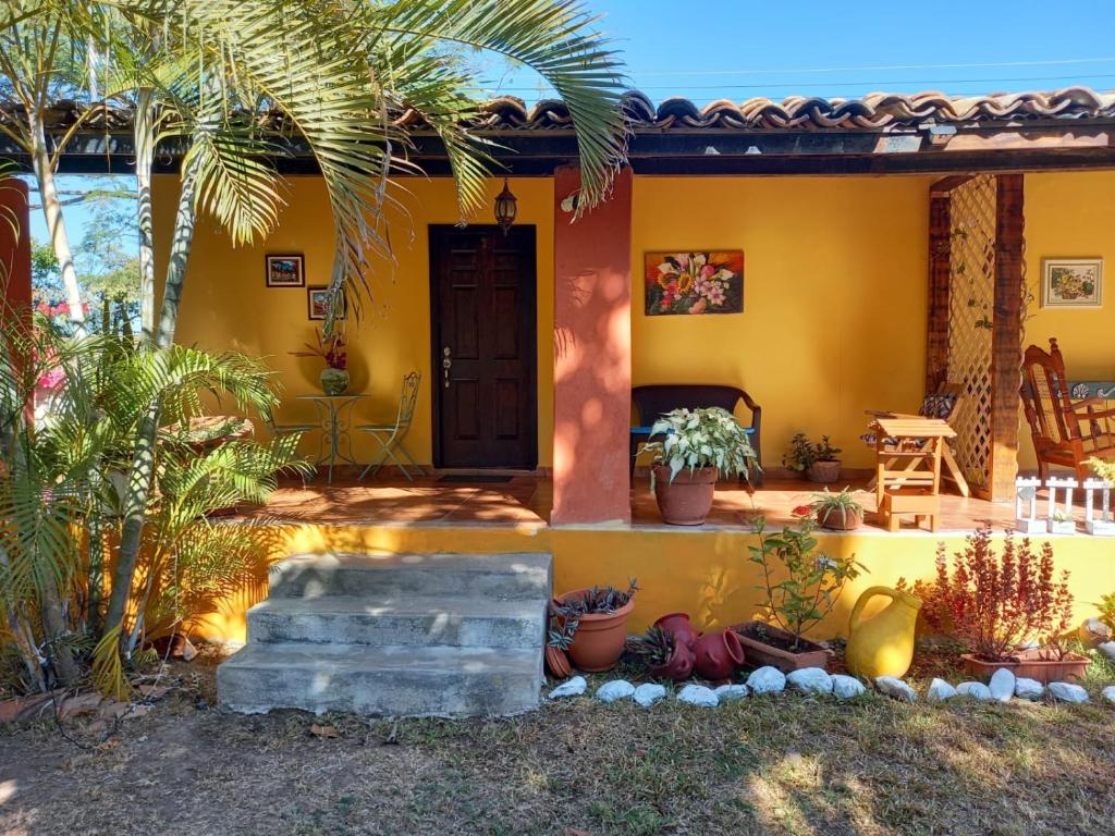 a yellow house with a palm tree and a porch at Magnificent Private Room Near Airport #1 in Comayagua