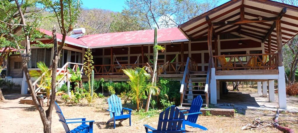 a house with blue chairs in front of it at Piancito, Playa el Coco in Escameca