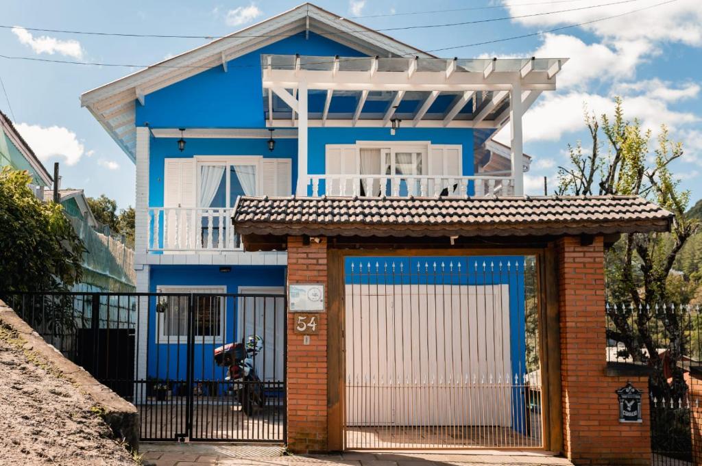 uma casa azul com um portão e uma cerca em Casa da bela Vista em Gramado