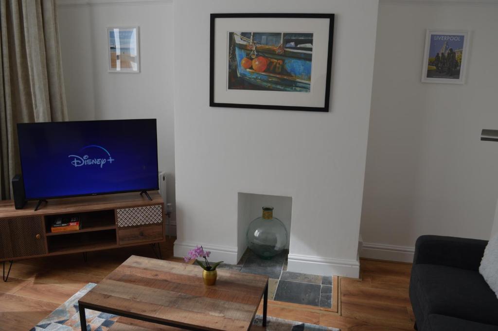 a living room with a tv and a coffee table at Library House in Liverpool