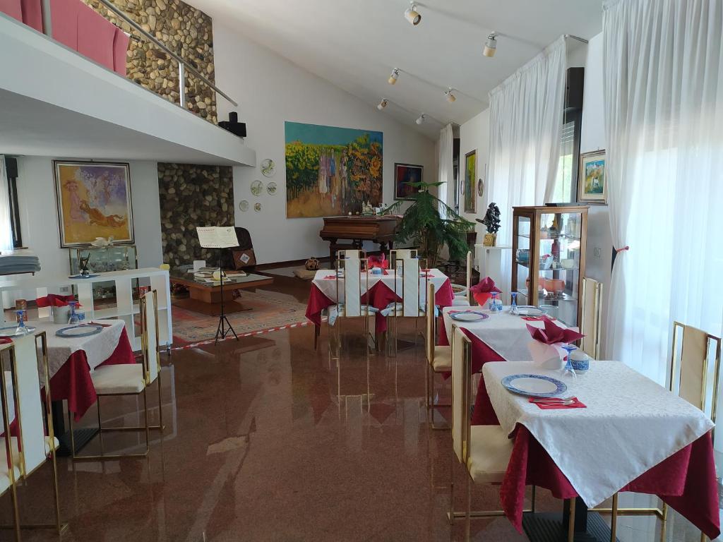 a restaurant with tables and a piano in a room at B&B Cà d'Artisti in Caorle
