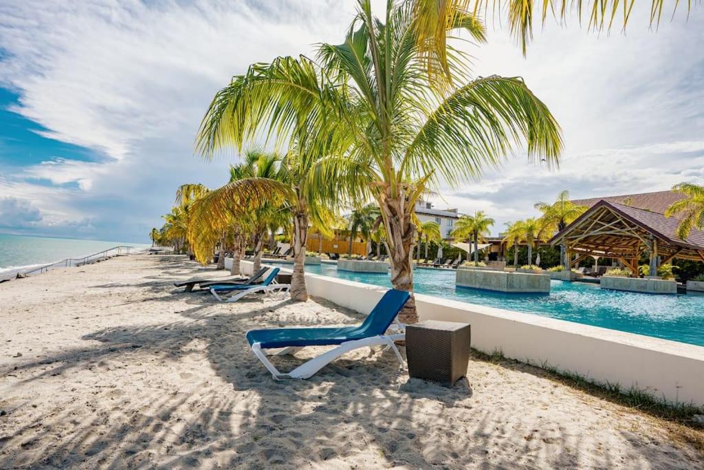 una playa con tumbonas y una palmera en Steps to Puntarena Beach Club and Restaurants - Amazing Location - Sleeps 9 en Boca de Río Hato