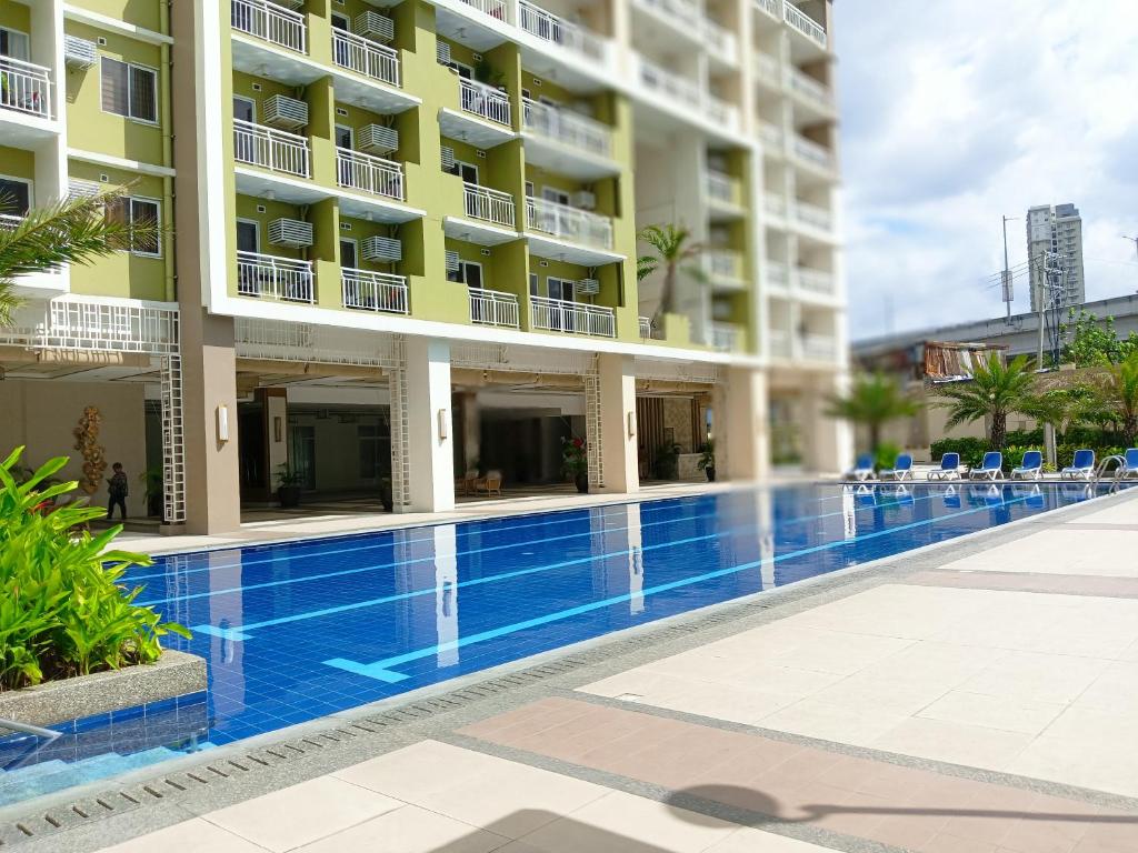 una piscina frente a un edificio en The Celandine A Bonifacio Balintawak Condotel en Manila