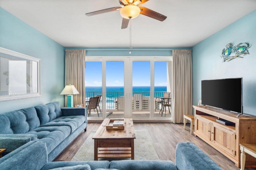 uma sala de estar com um sofá azul e uma televisão de ecrã plano em Sea-Renity at Laketown Wharf #1607 by Nautical Properties em Panama City Beach