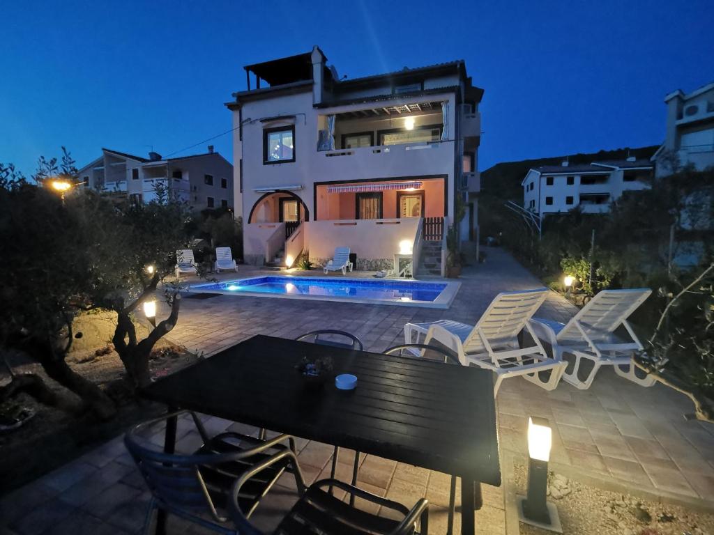 a villa with a swimming pool at night at Apartments with a swimming pool Punat, Krk - 5378 in Punat