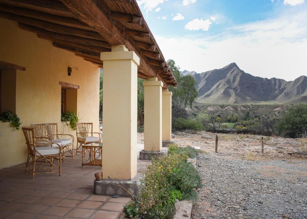 eine Terrasse mit Stühlen und Tischen mit Bergen im Hintergrund in der Unterkunft Hospedaje Finca la Encantada in Seclantás