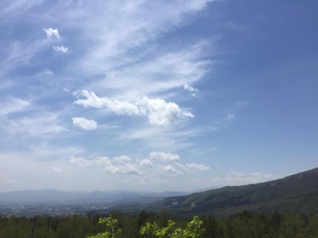 una vista de un cielo azul con nubes y árboles en Haiji, en Shizukuishi