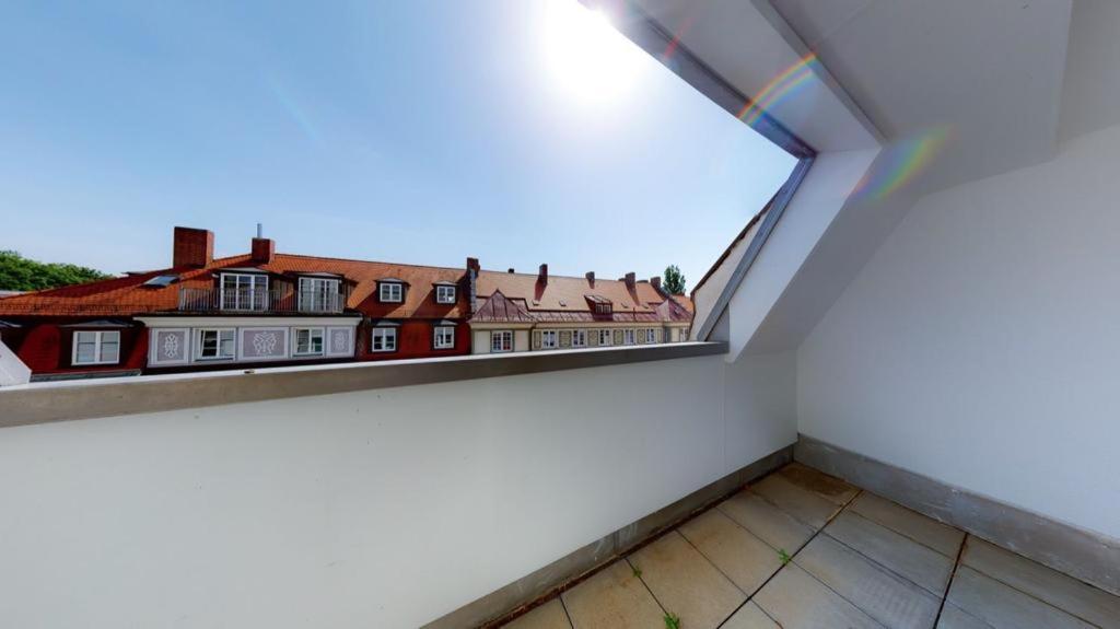 Cette chambre dispose d'un balcon avec vue sur les bâtiments. dans l'établissement Spacious 4 Bedroom Apartment near City Center, à Munich