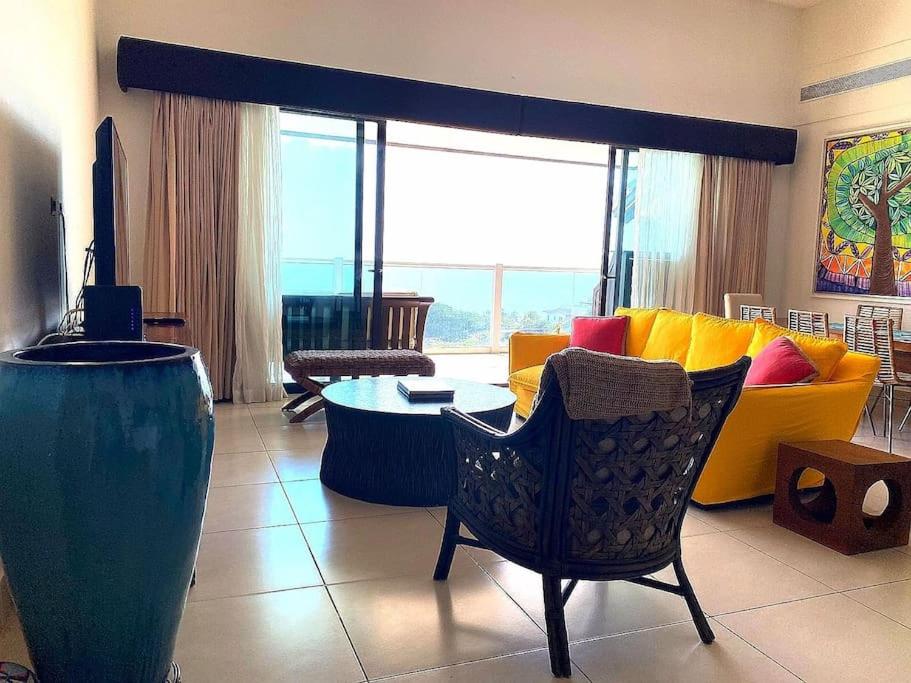 a living room with a yellow couch and a table at Disfruta hermosa vista al mar! in San Carlos