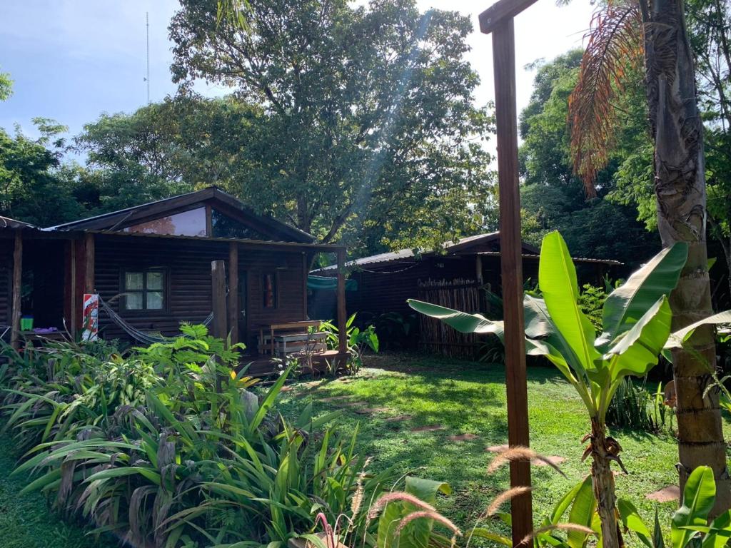 ein kleines Haus inmitten eines Gartens in der Unterkunft Los Bananos - Big Wood Cabin in Puerto Iguazú