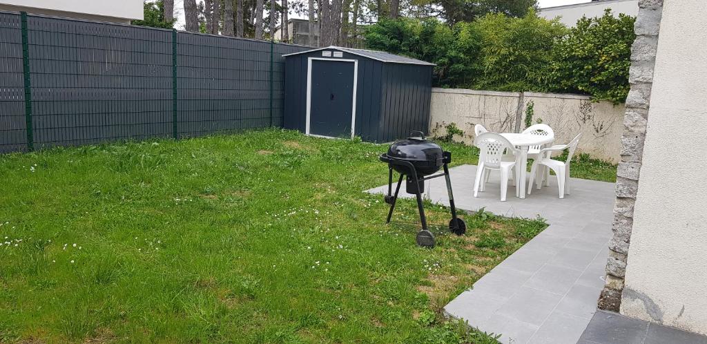 eine Kamera auf einem Stativ in einem Hof mit einem Tisch in der Unterkunft La Patalisse, maison type 3 et jardin in Joue-les-Tours